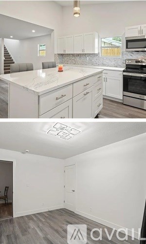 A kitchen with white cabinets and a countertop with a stove and microwave.