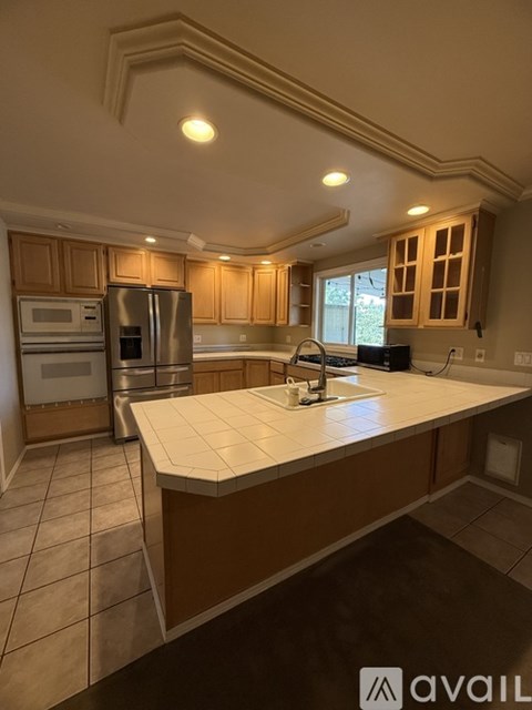 A kitchen with wooden cabinets and a white countertop.