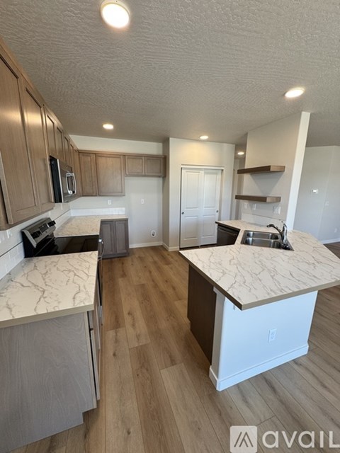 A kitchen with wooden cabinets and a marble countertop.