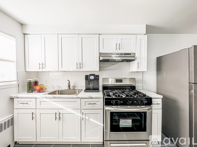 A kitchen with white cabinets and a stainless steel refrigerator.