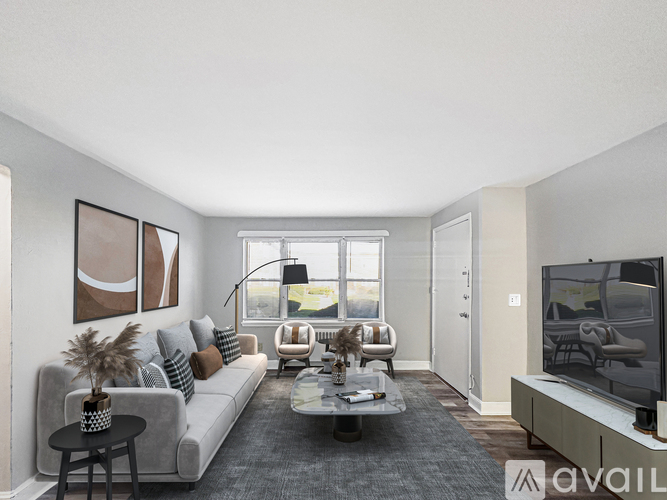 A living room with a grey couch, a coffee table, a television, and a window.