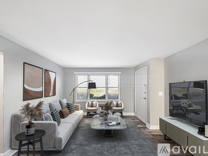 A living room with a grey couch, a coffee table, a television, and a window.