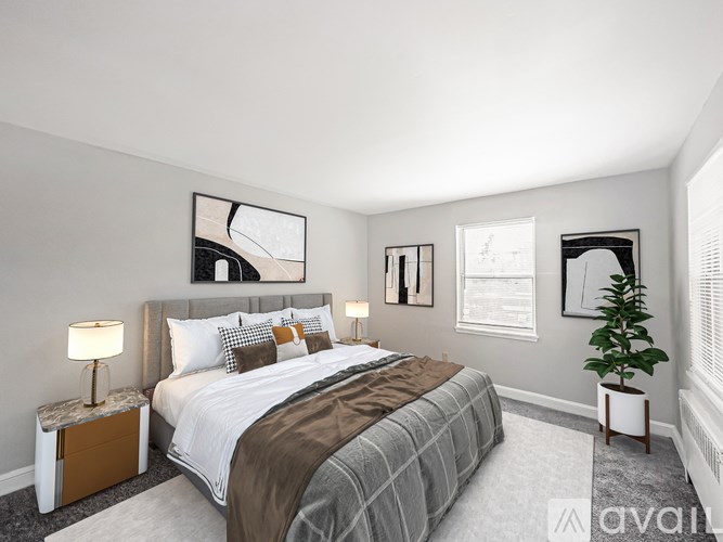 A bedroom with a large bed and a plant on the side table.