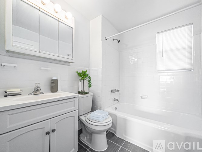 A white bathroom with a toilet, sink, and bathtub.