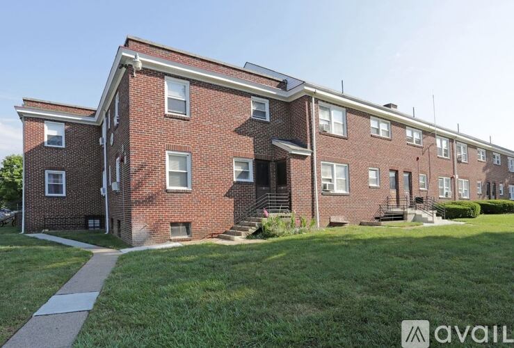 A brick apartment building with a grassy front yard.