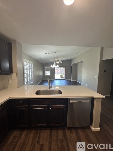 A kitchen with dark wood cabinets and a white countertop.