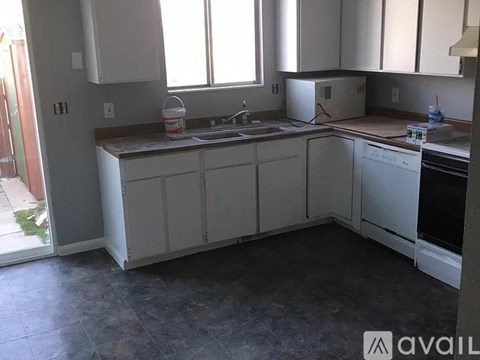 A kitchen with white cabinets and appliances is available for rent.
