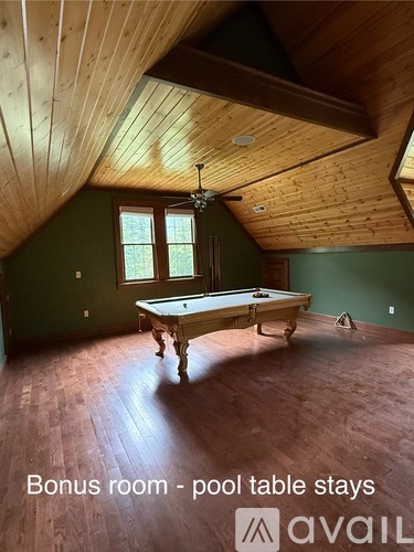 A room with a pool table and a ceiling fan.