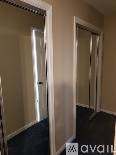 A hallway with a door on the left and a glass door on the right.