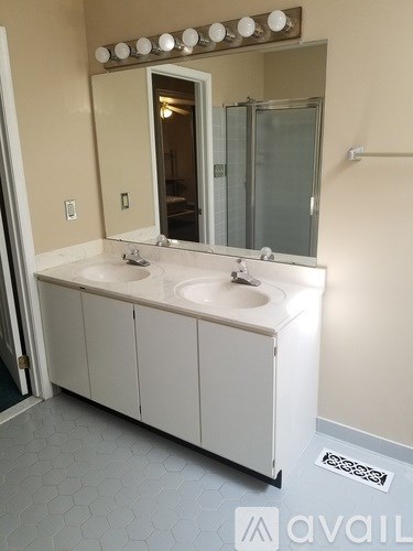 A bathroom with a white vanity and a mirror above it.
