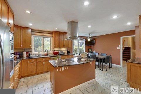 A kitchen with wooden cabinets and a marble countertop.