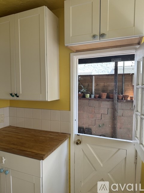 A kitchen with white cabinets and a wooden countertop.