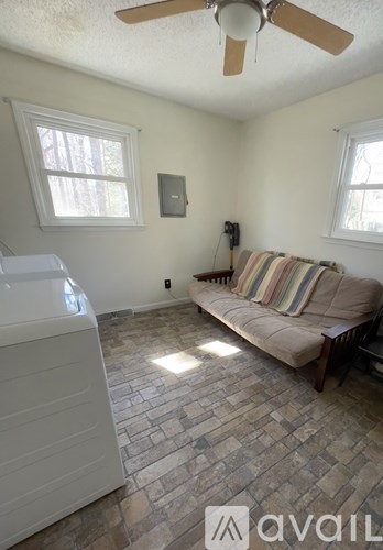 A living room with a couch and a fan.