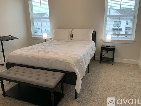A bedroom with a large bed and a bench in front of it.