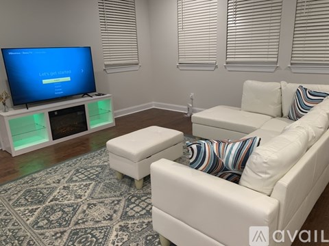 A living room with a television displaying "Let's get started!" and a white couch with colorful pillows.
