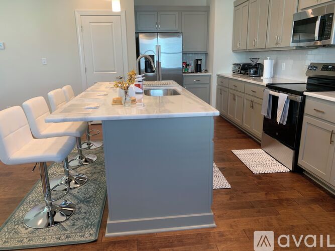 A kitchen with a table and chairs in the foreground and a refrigerator in the background.