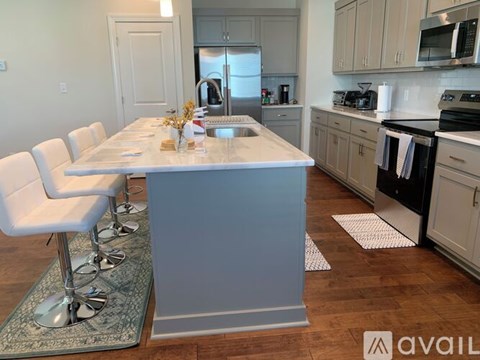 A kitchen with a table and chairs in the foreground and a refrigerator in the background.