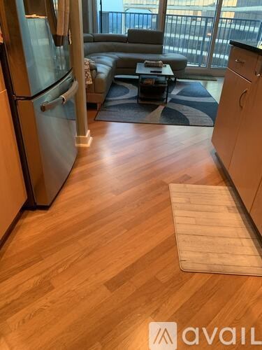 A kitchen with a refrigerator and a couch.