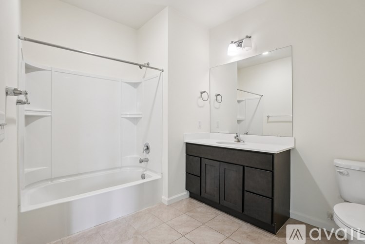 A bathroom with a white tub, sink, and mirror.