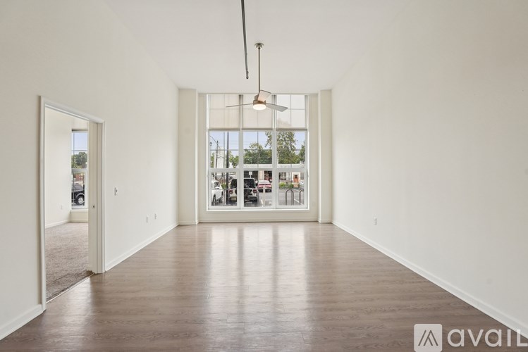 A large empty room with a view of a store through the glass door.