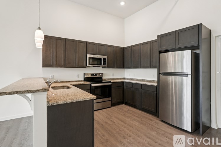 A kitchen with dark brown cabinets and stainless steel appliances.