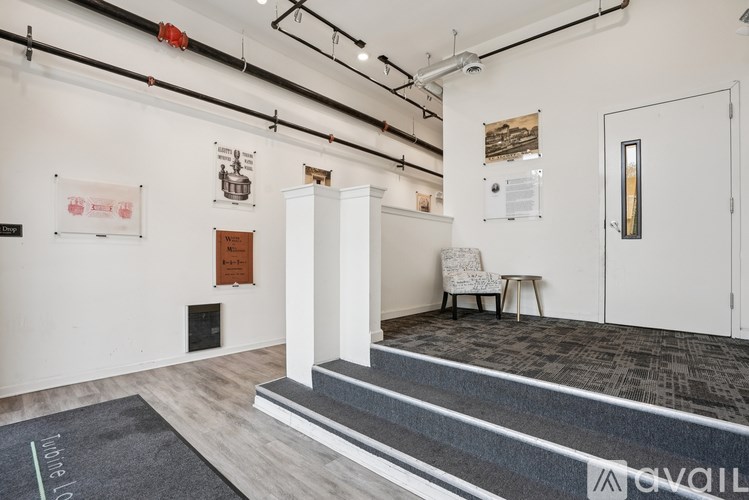 A room with a white door, a chair, and a wall with pictures and posters.