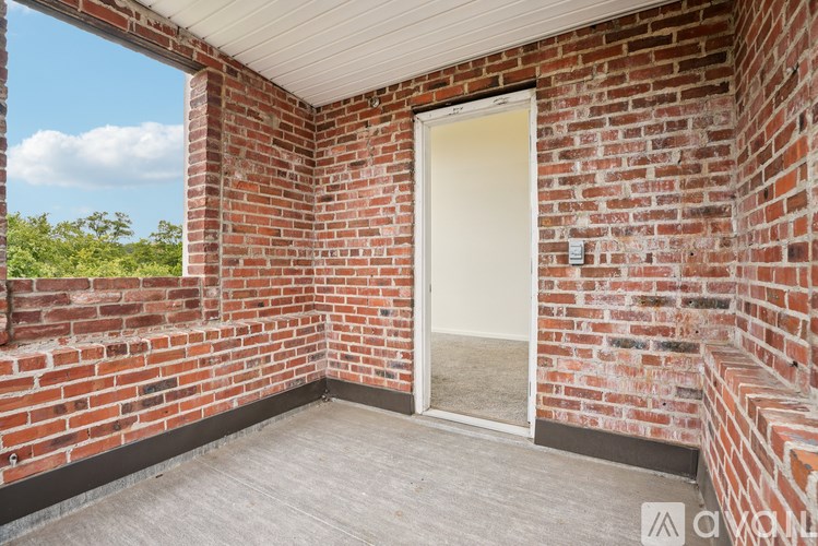A room with a brick wall and a door leading outside.