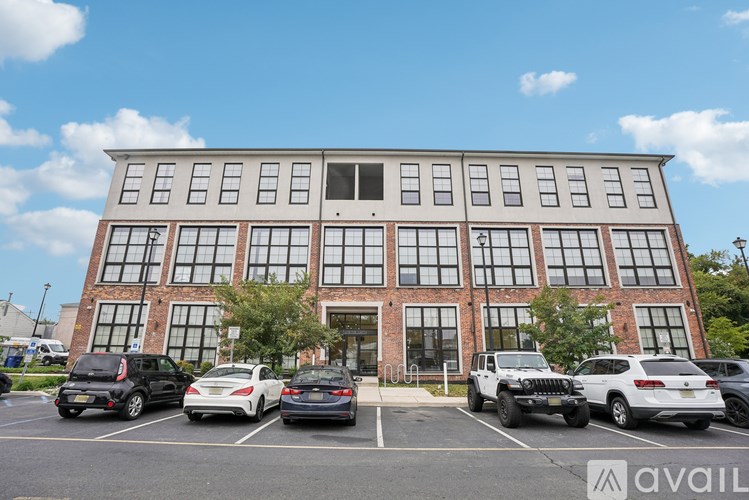 A parking lot with cars and a building with a large window.