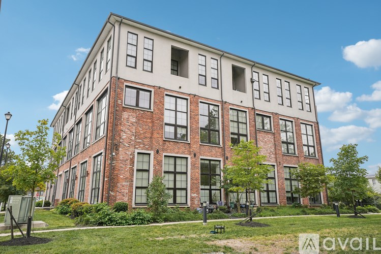 A large red brick building with a white section on the top floor.