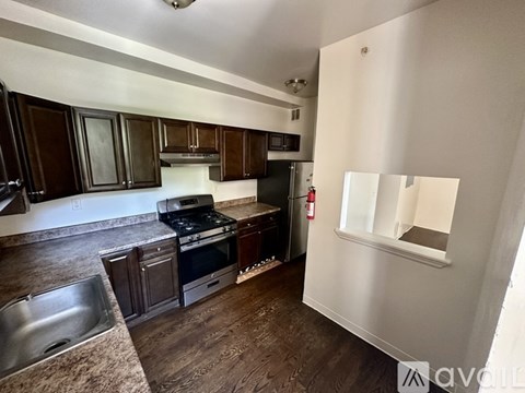 A kitchen with dark wood cabinets and a stove top oven.