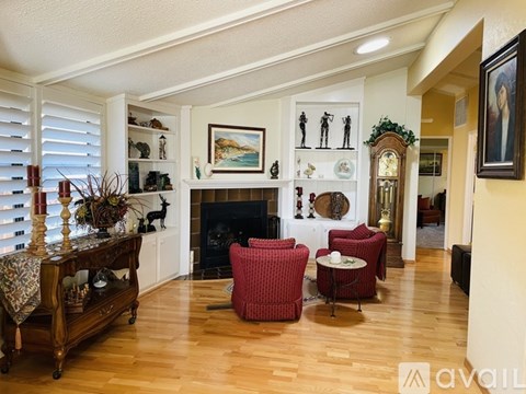 A living room with a fireplace and a painting on the wall.