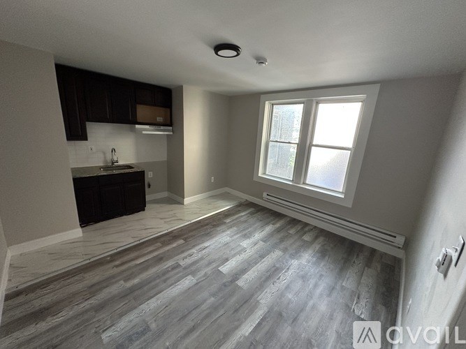 A spacious kitchen with dark wood cabinets and a large window.