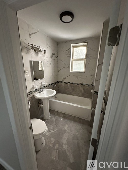 A bathroom with a toilet, sink, and bathtub.