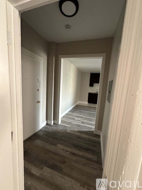 A hallway with a white door and a grey floor.
