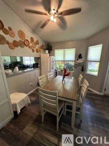 A dining room with a wooden table and chairs.