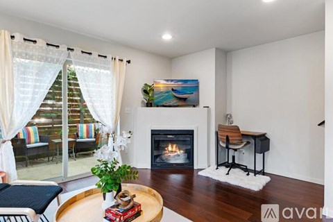 A living room with a fireplace and a painting on the wall.