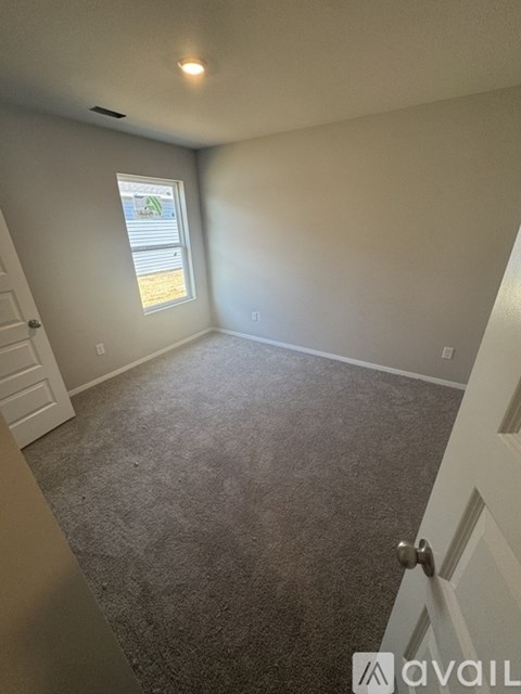 A room with a carpeted floor and a window.