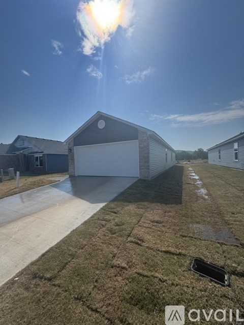 A sunny day with a clear blue sky and a building with a white garage door in the foreground.