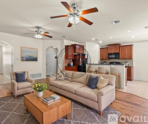 A living room with a beige couch, a coffee table, and a ceiling fan.