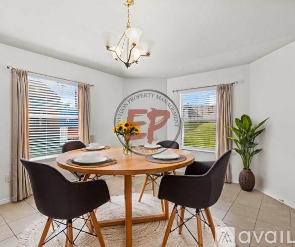 A dining room with a round table and chairs.