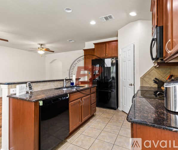 A kitchen with black appliances and wooden cabinets.