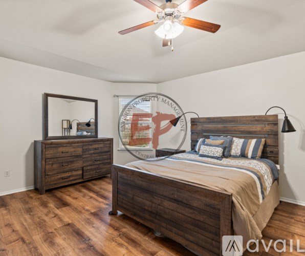 A bedroom with a bed, dresser, and mirror.