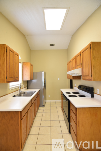 A kitchen with wooden cabinets and a white counter top.