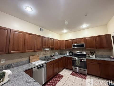 A kitchen with brown cabinets and a stove top oven.