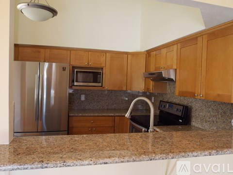 A kitchen with wooden cabinets and granite countertops.