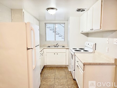 A kitchen with white appliances and cabinets.