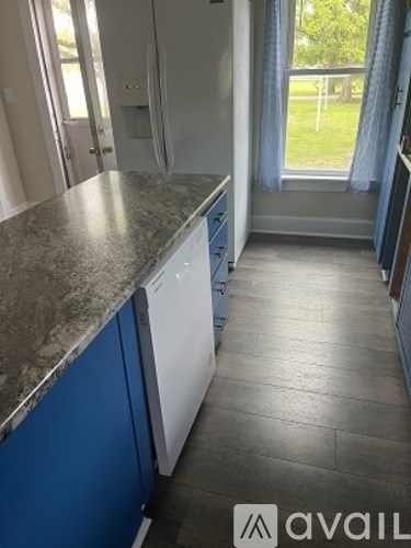 A kitchen with blue cabinets and a marble countertop.