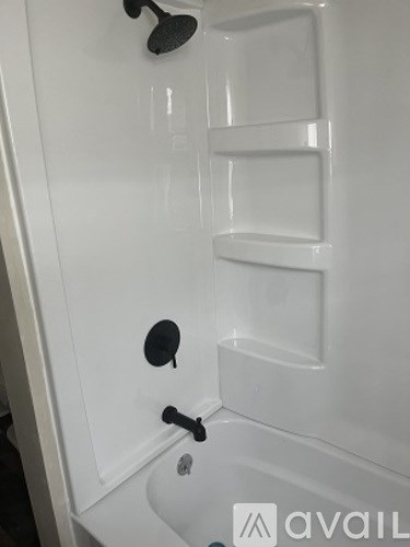 A white bathroom cabinet with a black handle and a black circular object on it.