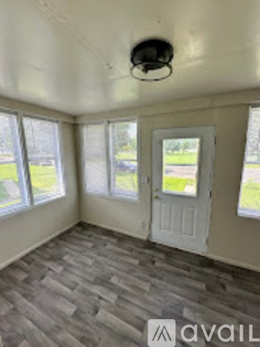 A room with a grey carpet and a white door.