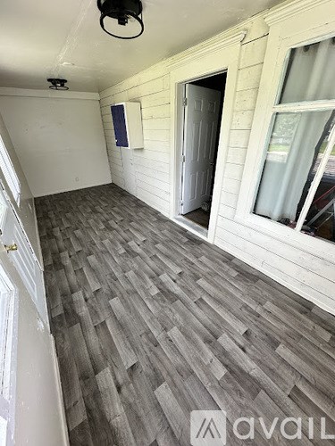 A room with wooden flooring and a window.